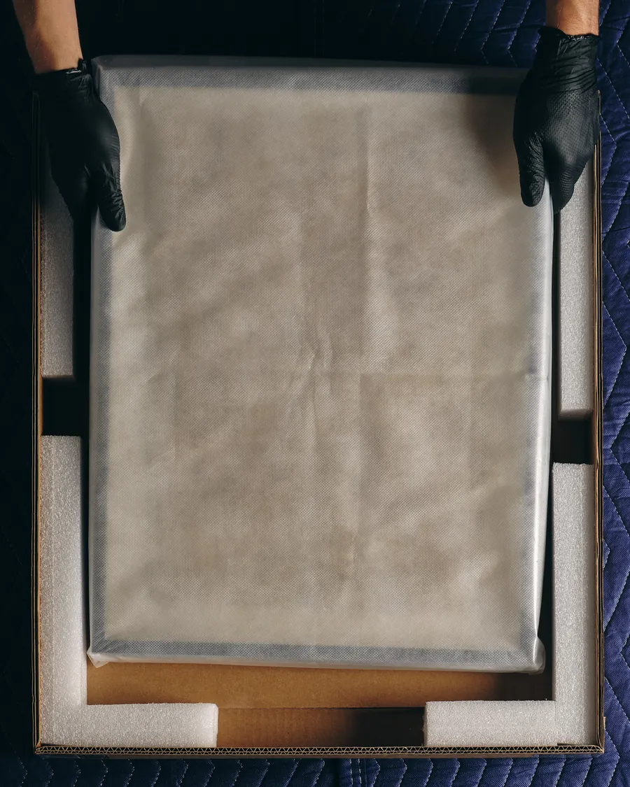 A work seen from above, wrapped and seated in its foam profiles.