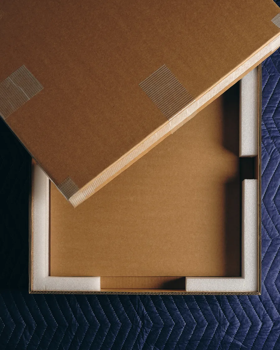 A boarded work resting on its padded bench, edges protected.