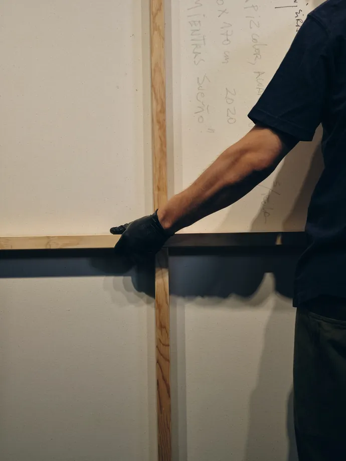 A technician sliding a large boarded work into place.